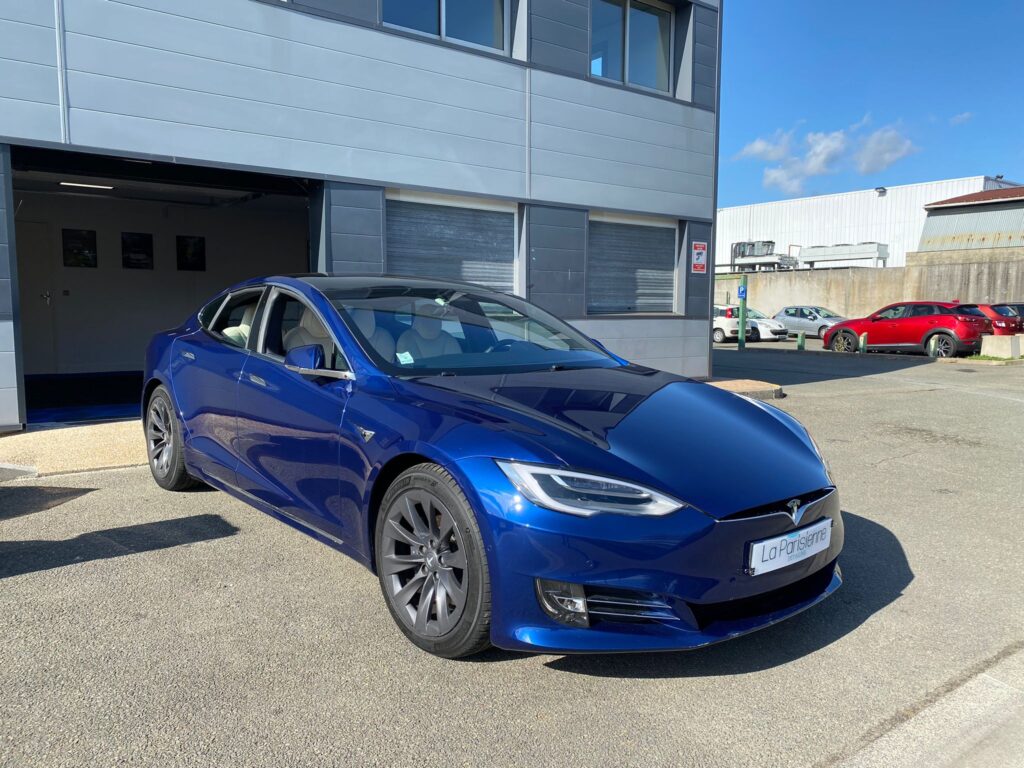 Voiture de marque Tesla De couleur Bleu. La voiture est garée a l'extérieur du garage de La Parisienne Detailing